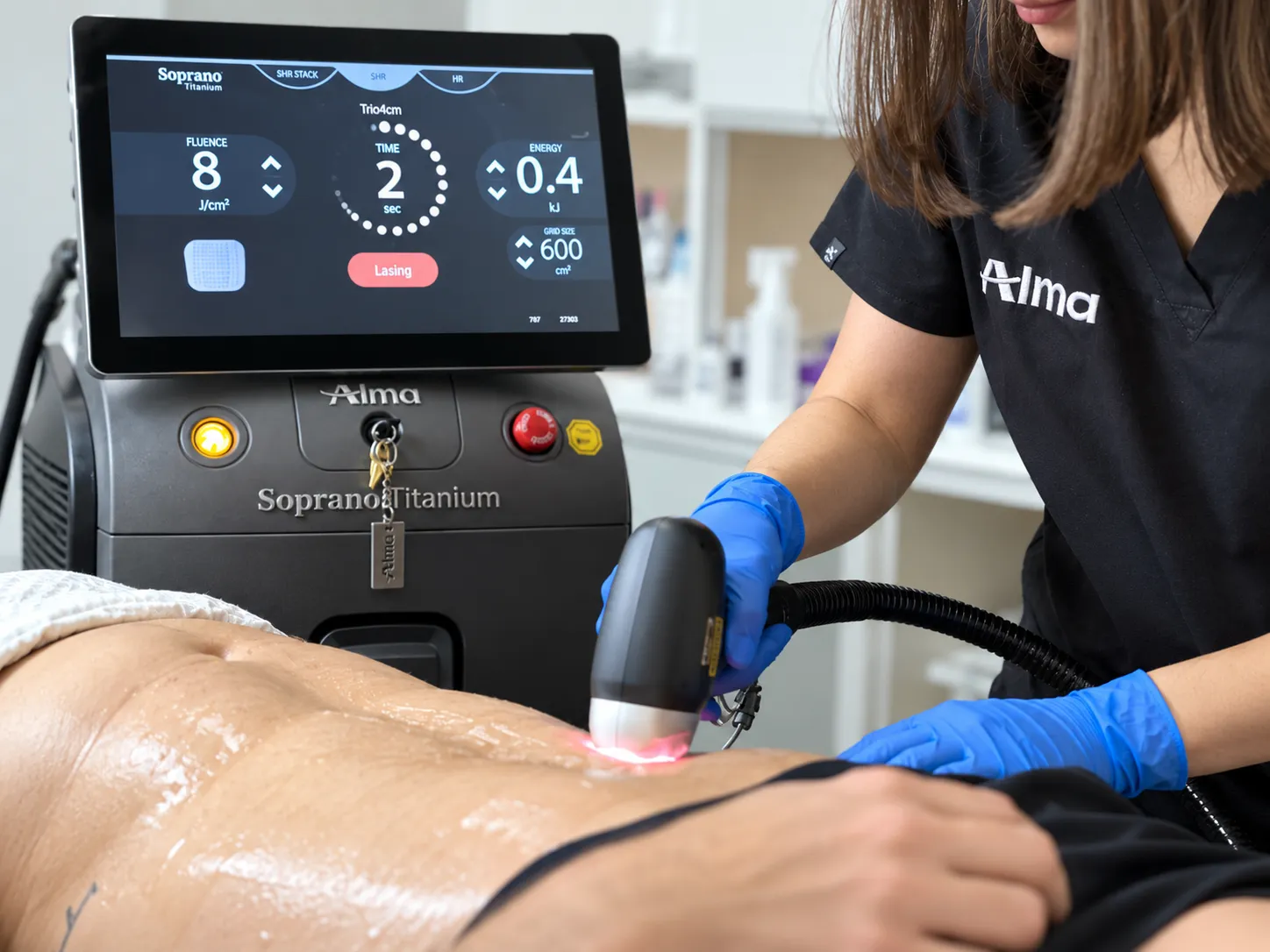 Laser handpiece being used near a client’s shoulder, with protective eyewear on