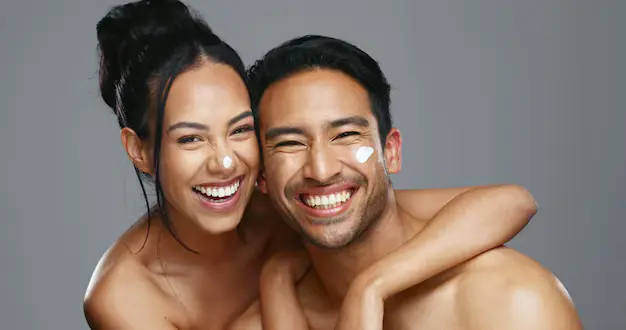 A smiling, diverse couple in Delhi showcasing their clear, glowing skin after a HydraFacial treatment, perfect for wedding or event preparation in 2025.